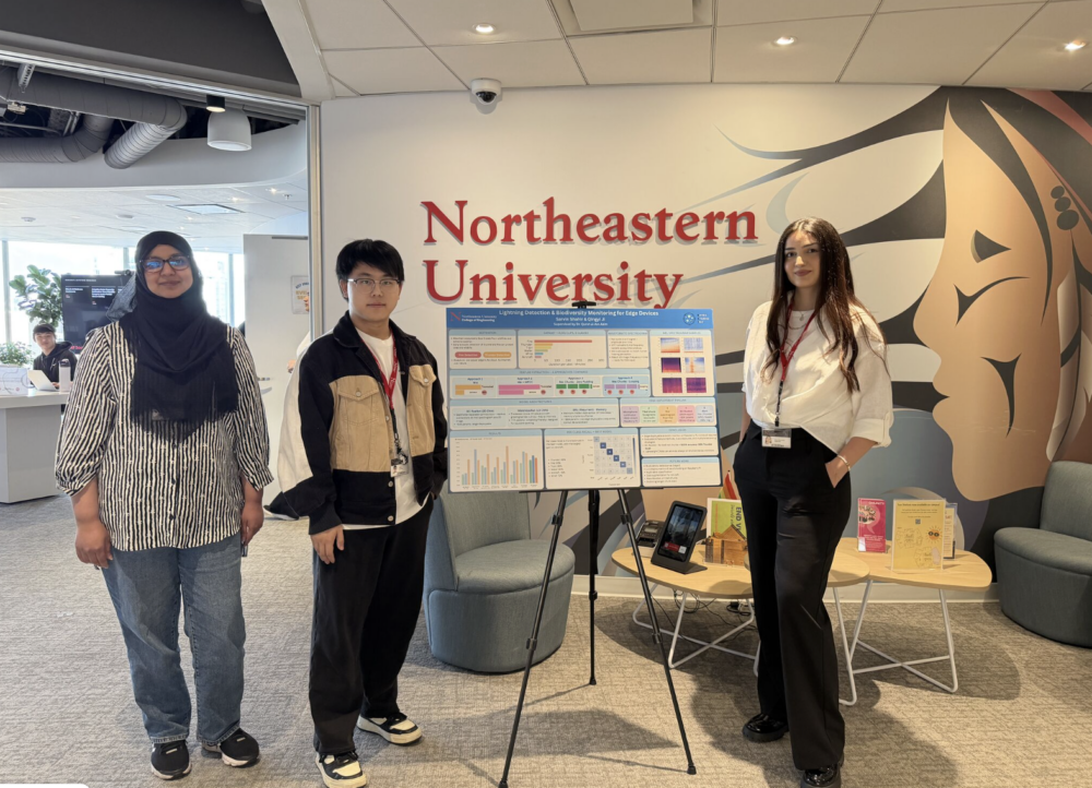 Researchers Sarvin Shahir, Qingyi Ji, and Dr. Qurat-ul-Ain Azim stand alongside a research presentation poster titled "Lightning Detection & Biodiversity Monitoring for Edge Devices" in front of the Northeastern University wall sign
