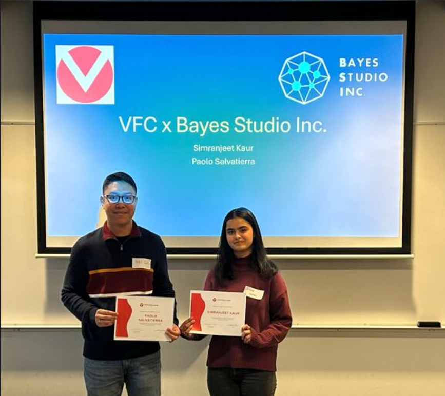 Interns Paolo Salvatierra and Simranjeet Kaur holding certificates in front of a presentation screen reading "VFC x Bayes Studio Inc." with the Venture for Canada and Bayes Studio logos.